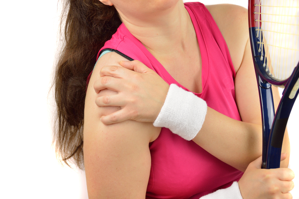 woman tennis player with a shoulder injury isolated over white background